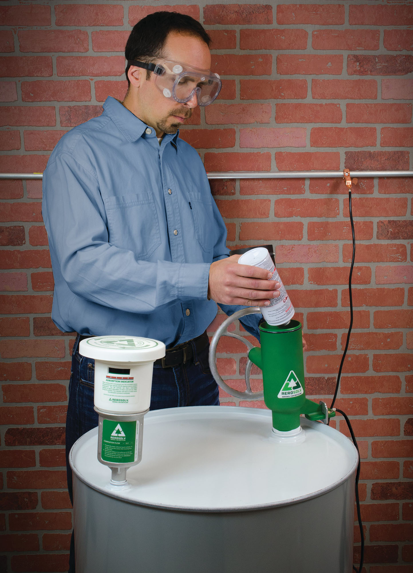 Worker using Aerosolv system to empty aerosol can for recycling