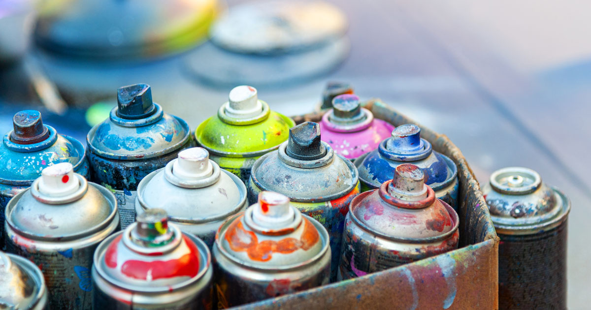 Empty cans of spray paint in box ready for disposal