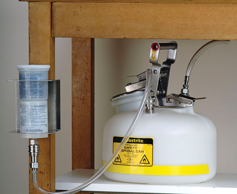 Justrite white HPLC hazardous waste container with carbon filter mounted on workstation with filter wall bracket
