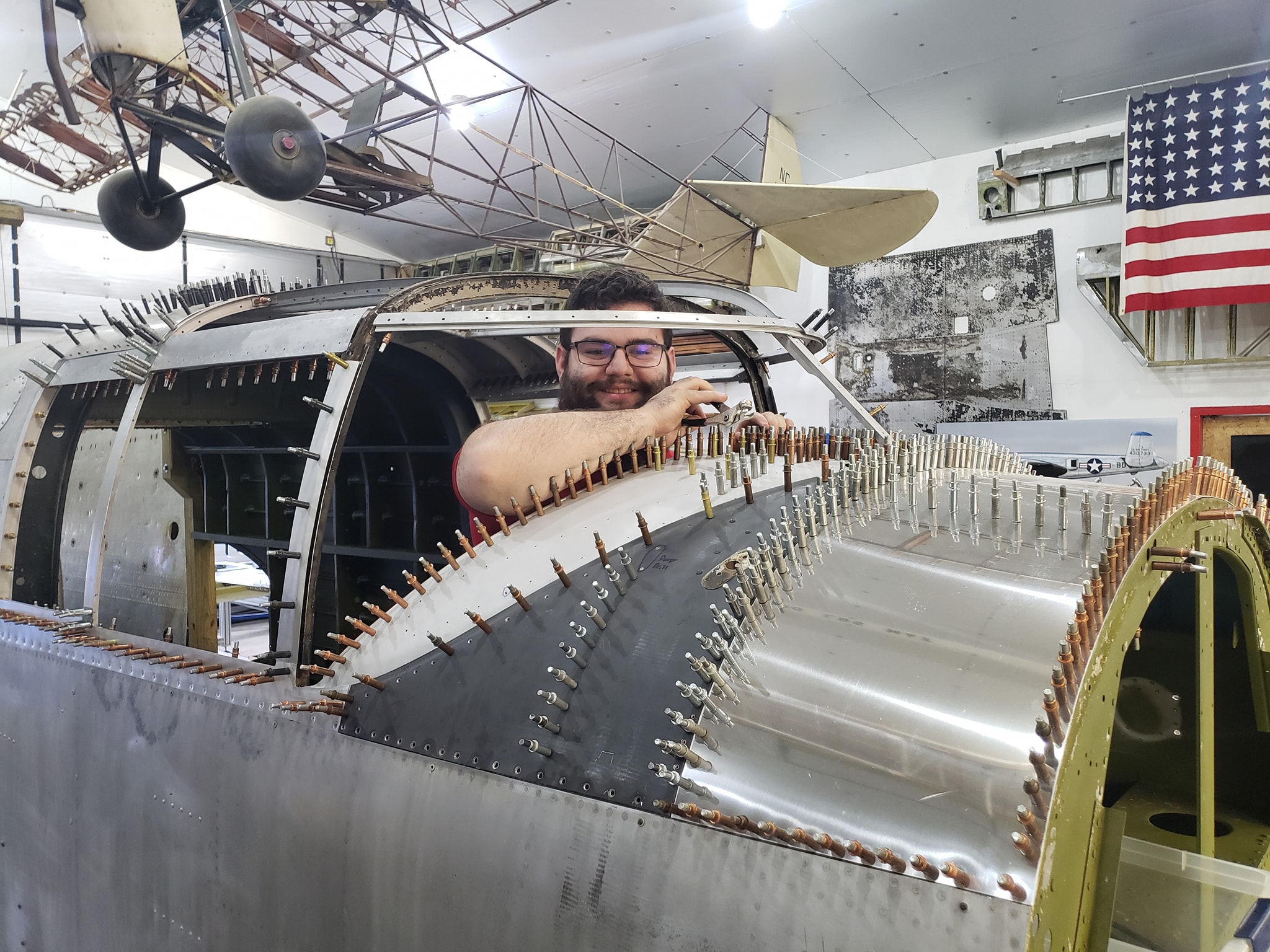 Student smiles from cockpit of B-25 Mitchell during aircraft restoration program