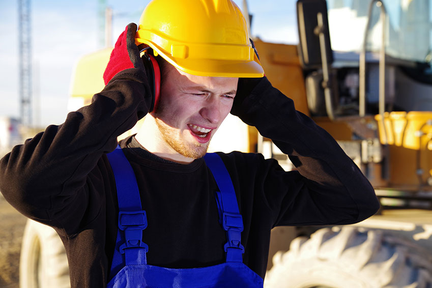 man with hands over ears industrial sound barriers
